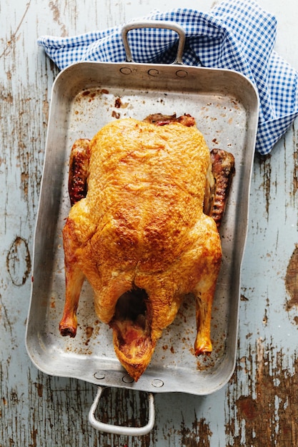 Foto gratuita pato asado al horno con verduras en sartén sobre fondo de madera vieja. vista superior.