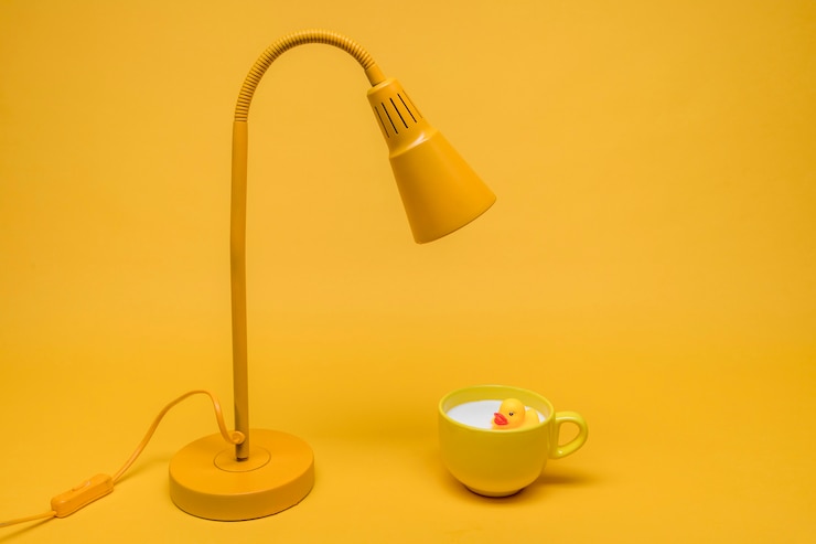Foto gratuito pato de goma en taza de leche debajo de lámpara
