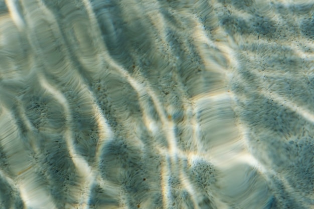 Patrón de agua ondulada abstracta en una piscina con reflejo de sol