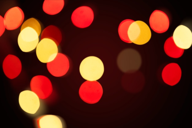 Patrón de bokeh rojo y amarillo sobre un fondo de pantalla oscuro