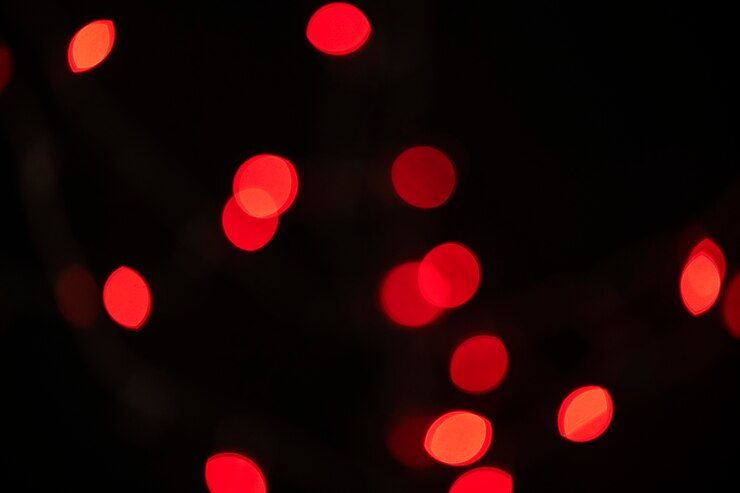 Foto gratuito patrón de bokeh rojo sobre un fondo de pantalla oscuro