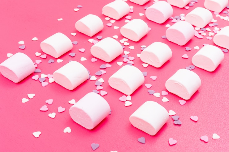 Foto gratuito patrón de malvavisco en superficie rosa