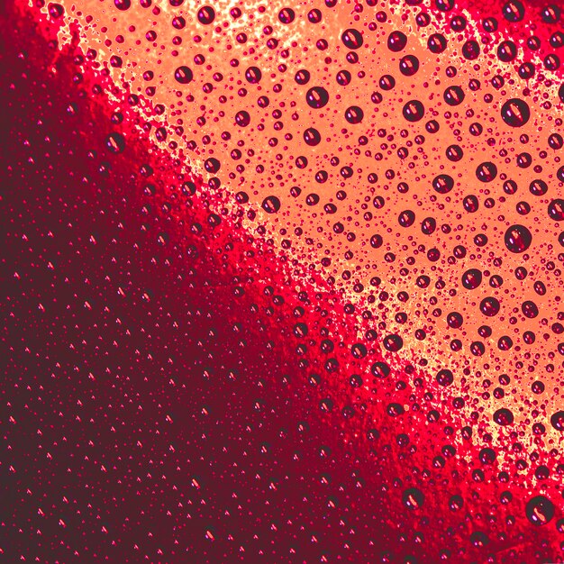 Patrón natural de gotas de agua sobre fondo rojo y naranja