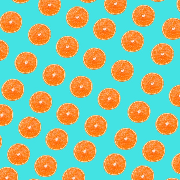 Un patrón de rodajas de naranjas sobre fondo turquesa