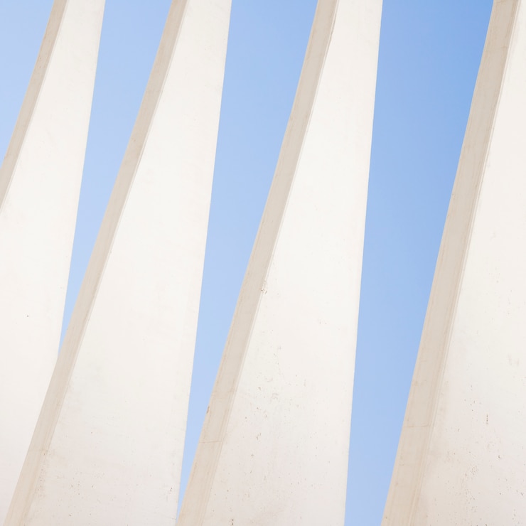 Foto gratuito patrón triangular de pared blanca contra el cielo azul.