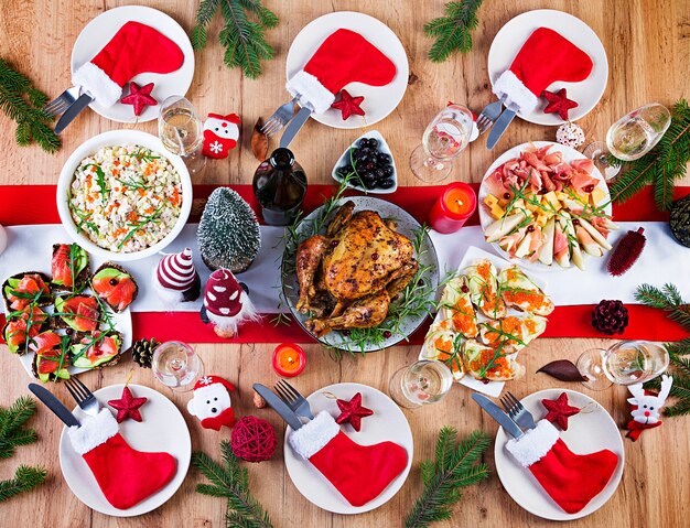 Pavo al horno. Cena de Navidad. La mesa navideña se sirve con un pavo, decorado con oropeles brillantes y velas. Pollo frito, mesa. Cena familiar. Vista superior, plano, arriba, espacio de copia