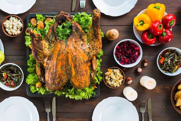 Foto gratuita pavo al horno con platos en mesa.