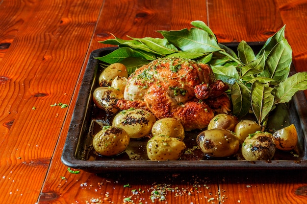 Foto gratuita pavo a la parrilla con patatas y hierbas en la mesa de madera