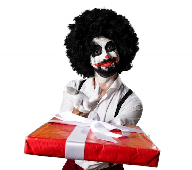 Foto gratuita payaso asesino sosteniendo un regalo