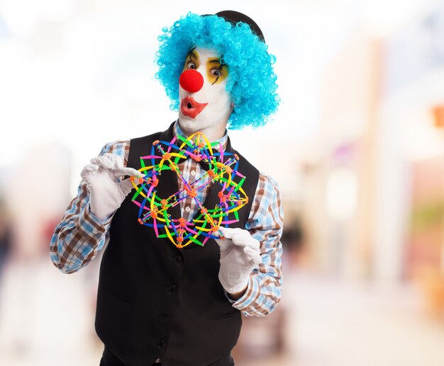 Payaso jugando con una esfera de plástico