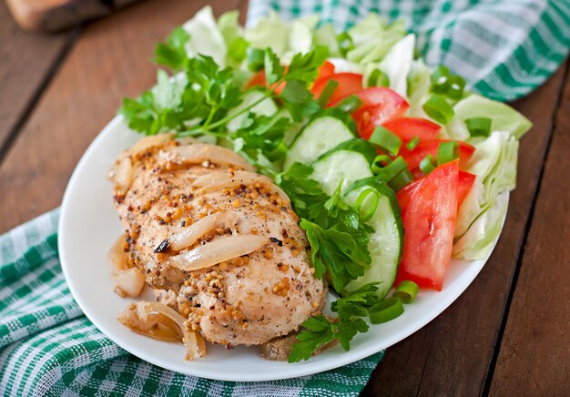 Pechuga de pollo al horno y verduras frescas en el plato