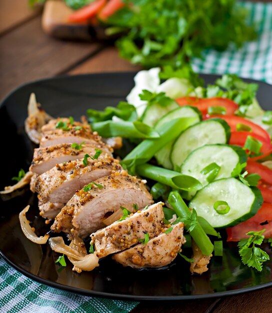 Pechuga de pollo al horno y verduras frescas en el plato