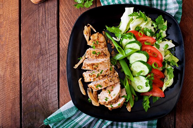 Pechuga de pollo al horno y verduras frescas en el plato