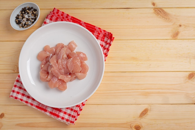 Foto gratuita pechuga de pollo cruda sobre la superficie de madera.