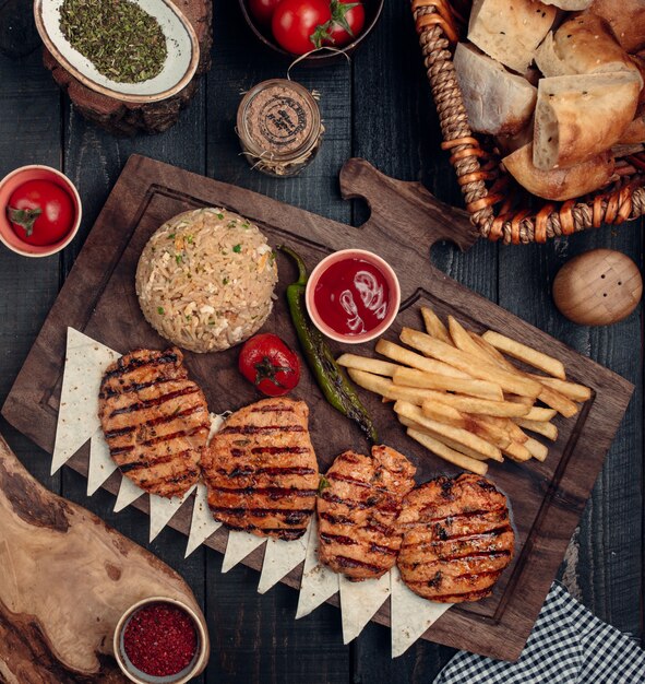 pechuga de pollo frita con papas fritas y vista superior de arroz