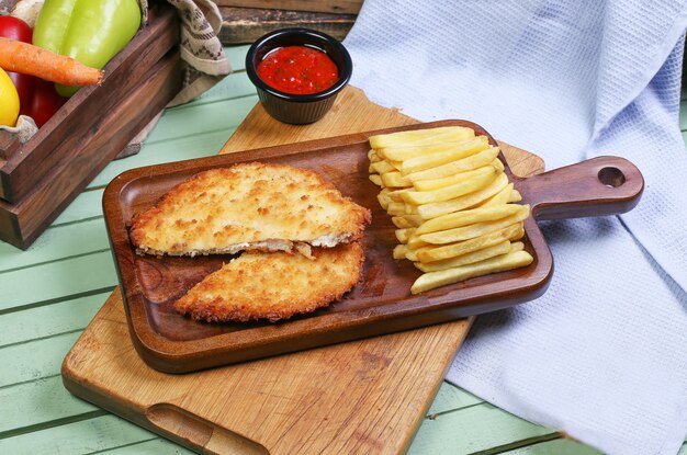 Pechuga de pollo a la parrilla con papas fritas.