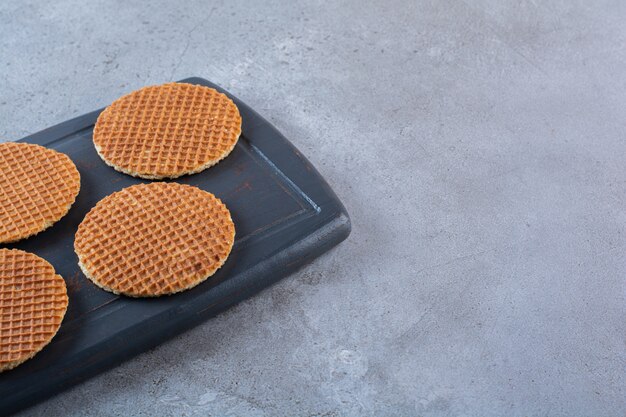 Pedazo de bocadillos stroopwaffle caseros marrones en una tabla de madera