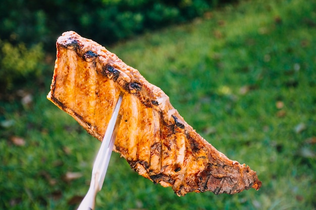 Pedazo de carne a la parrilla en el filo del cuchillo.