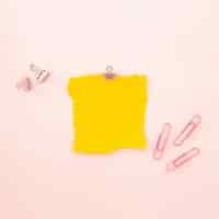 Foto gratuita pedazo de hoja amarilla sobre un fondo rosa