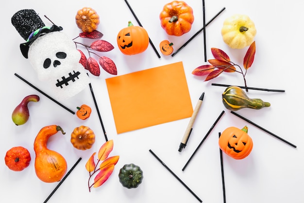 Pedazo de papel naranja rodeado de decoraciones de Halloween