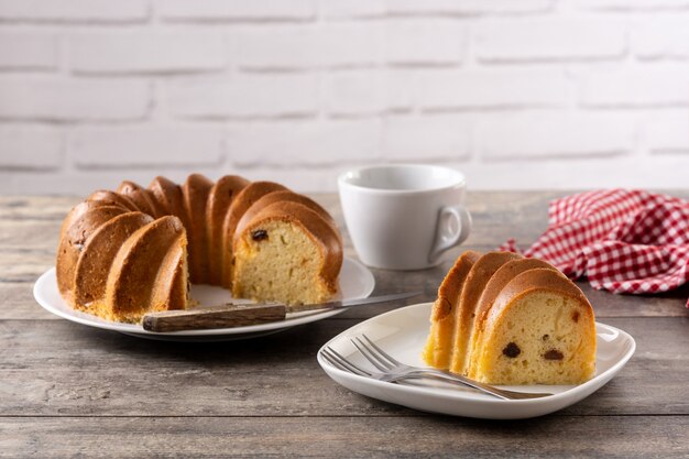 Pedazo de pastel bundt tradicional con pasas en mesa de madera