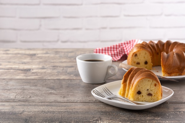 Pedazo de pastel bundt tradicional con pasas en mesa de madera