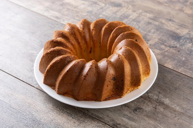 Pedazo de pastel bundt tradicional con pasas en mesa de madera