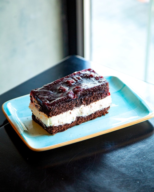 pedazo de pastel de chocolate con crema en un plato azul