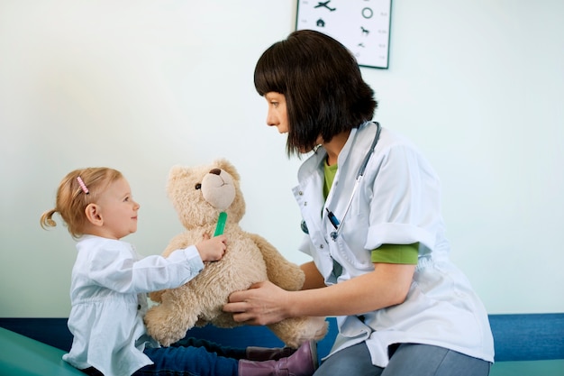 Pediatra jugando con el niño en el consultorio médico