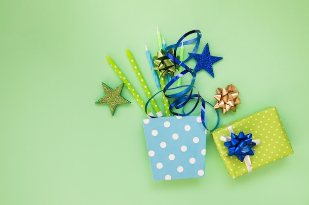 Pegatina de estrellas; velas; cinta; caja de regalo y arco sobre fondo verde