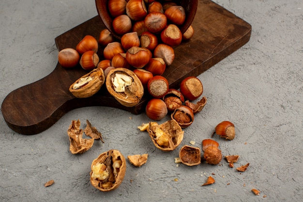 Pelado nueces avellanas y nueces en un escritorio gris