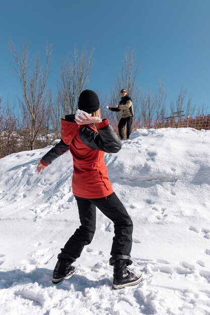 Pelea de bolas de nieve de personas de tiro completo