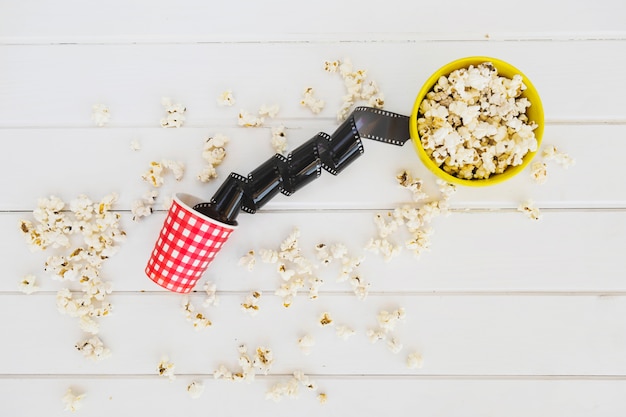 Foto gratuita película enrollada cerca de palomitas de maíz