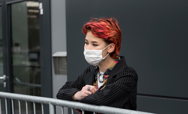 Foto gratuito pelirroja persona no binaria con una máscara médica fuera