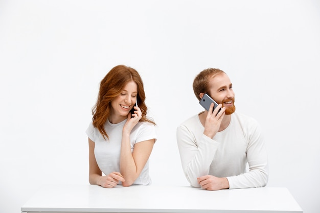 Pelirrojas feliz pareja hablando teléfono móvil