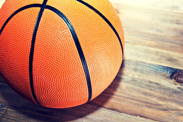 Pelota de baloncesto en piso de madera de madera dura.