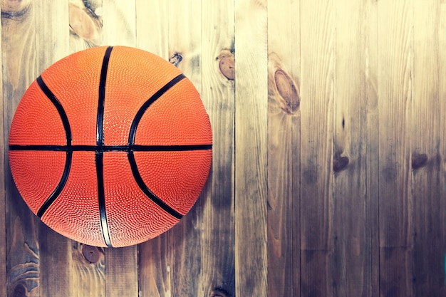 Pelota de baloncesto en piso de madera de madera dura.