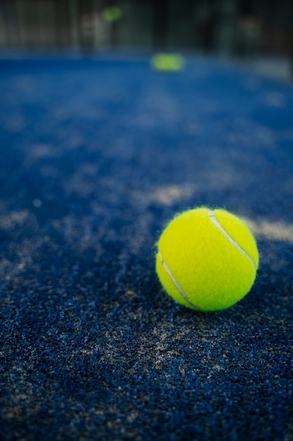 Pelota de tenis de alto ángulo en piso borroso