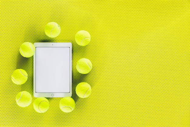 Pelotas de tenis alrededor de la tableta