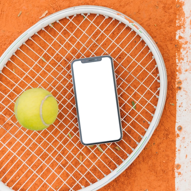 Pelotas de tenis con raqueta y móvil