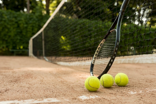 Foto gratuita pelotas de tenis y raqueta negra