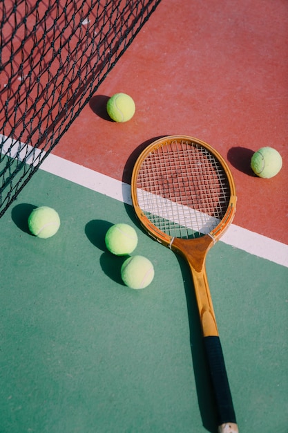 Pelotas de tenis y raqueta en pista