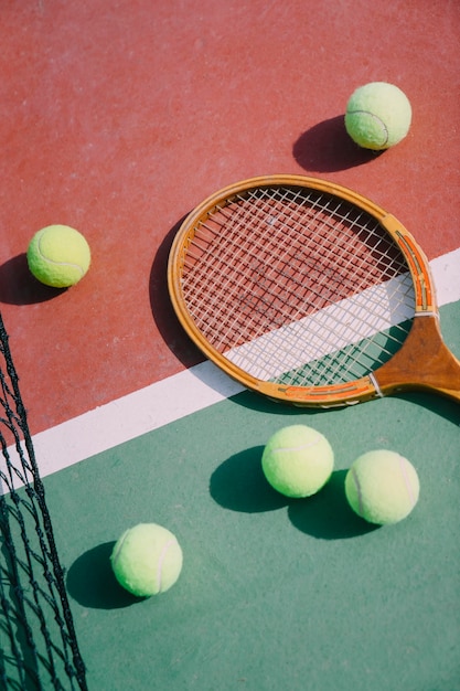 Pelotas de tenis y raqueta en el suelo