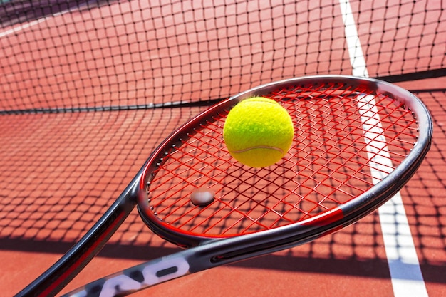 Pelotas de tenis y raquetas en la cancha de césped