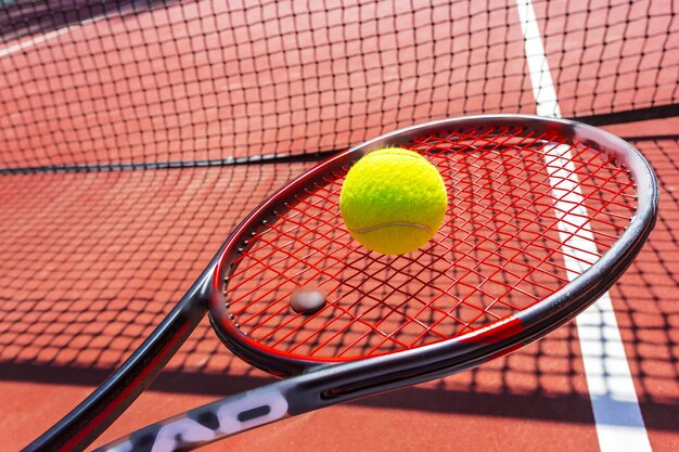 Pelotas de tenis y raquetas en la cancha de césped