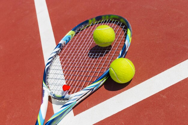Pelotas de tenis y raquetas en la cancha de césped