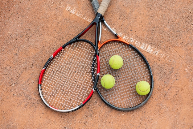 Pelotas de tenis con raquetas en la cancha