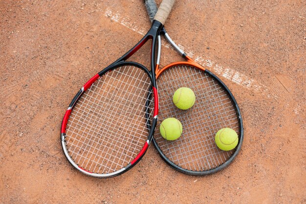 Pelotas de tenis con raquetas en la cancha