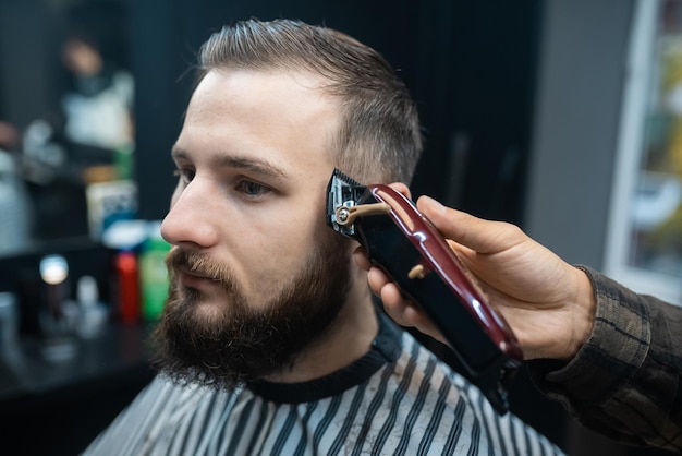 Peluquería y corte de cabello para hombres con cortadora de cabello en una peluquería o peluquería