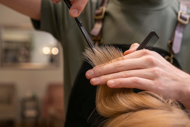 Peluquería cuidando el cabello de un cliente en interiores